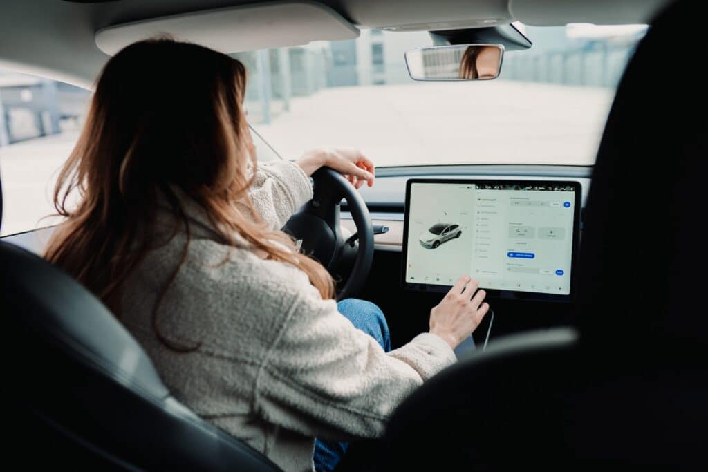 a driver touches a touchscreen control panel in a modern car