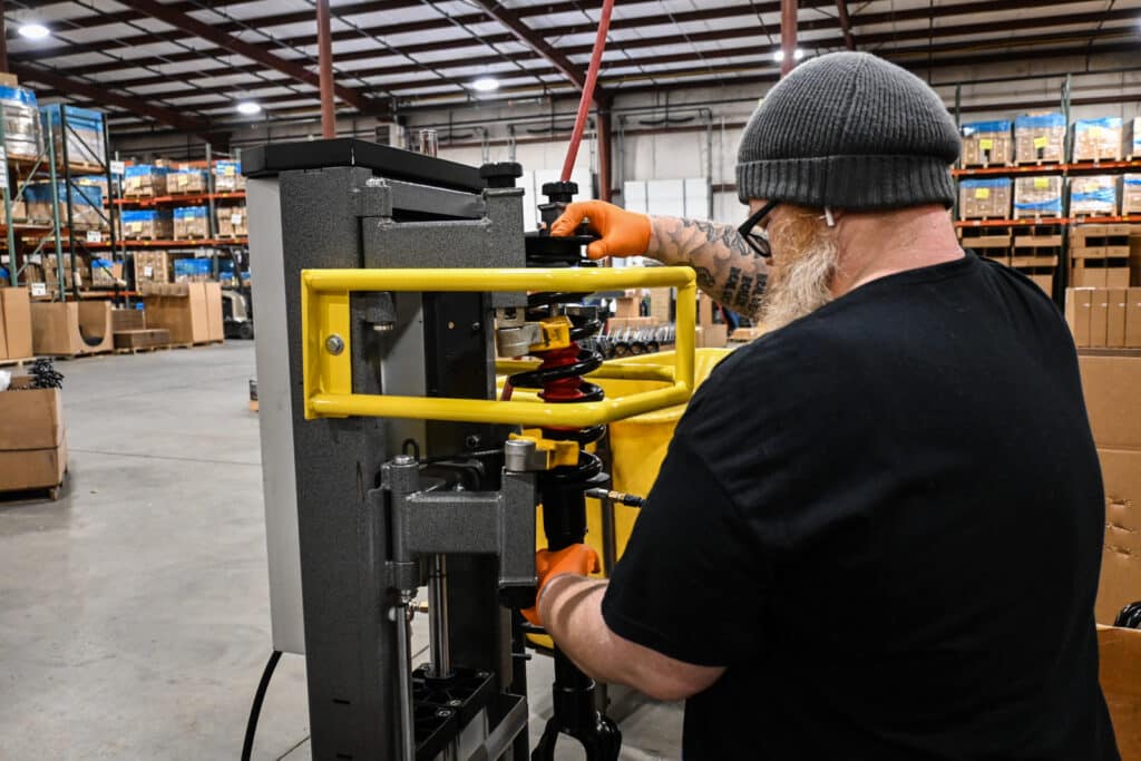 a strutmasters worker loads a strut assembly